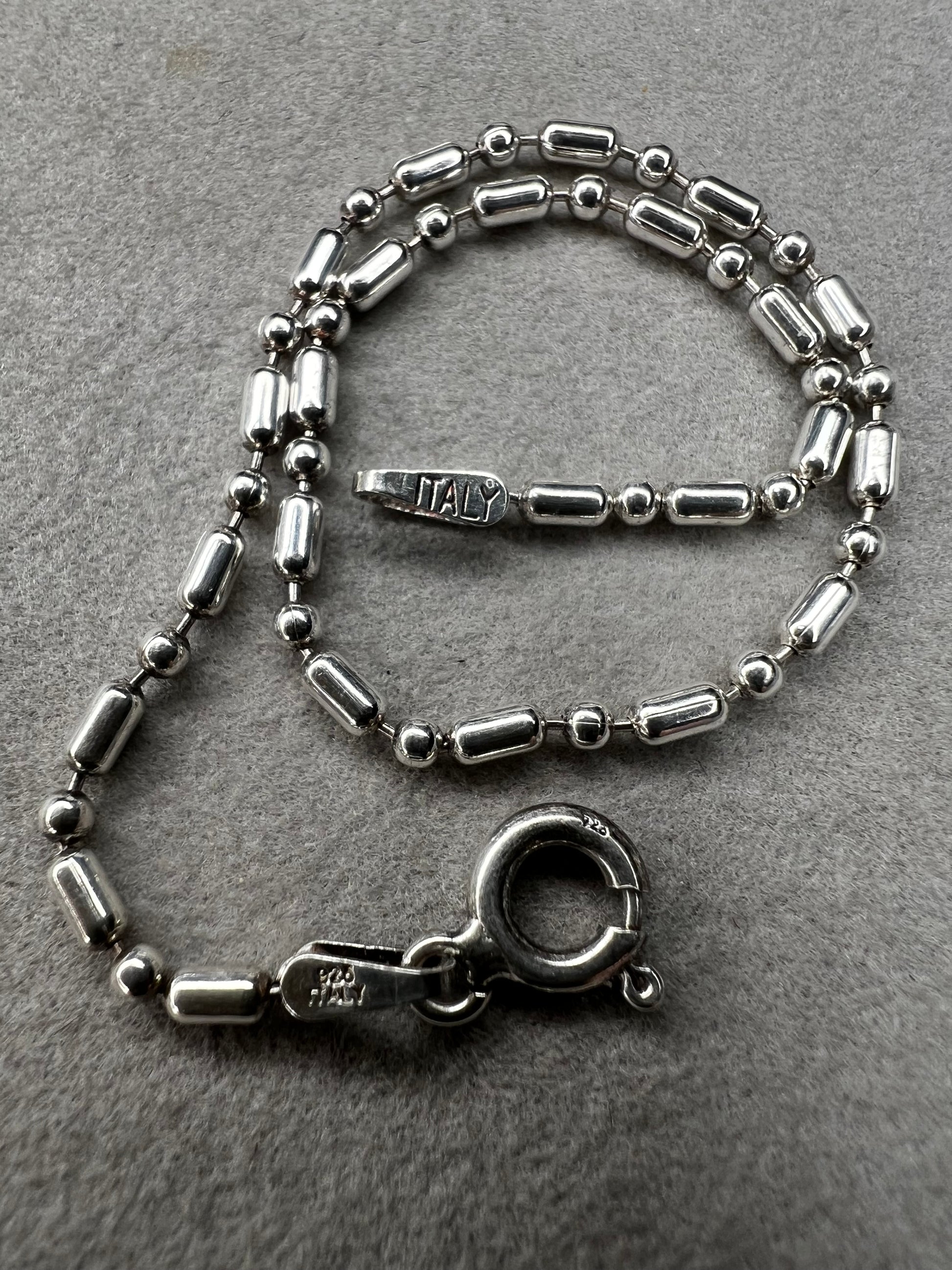 This sterling silver bracelet features an expertly crafted bead-and-tube link design, offering a distinctive alternative to traditional chains.