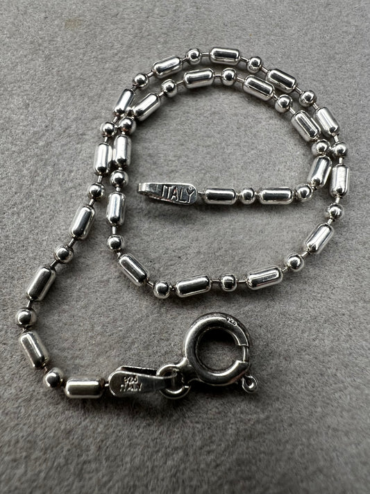 This sterling silver bracelet features an expertly crafted bead-and-tube link design, offering a distinctive alternative to traditional chains.