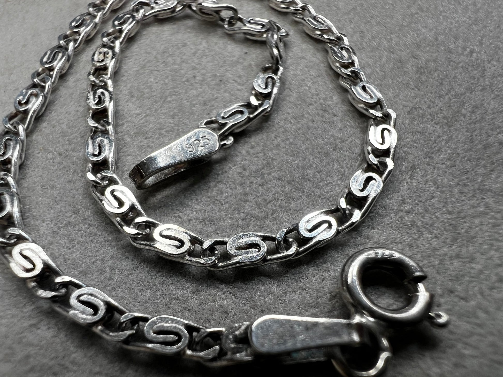 This sterling silver bracelet showcases a refined scroll link design, distinguishing it from standard chain styles. Expertly crafted for both durability and elegance, it offers a sophisticated accessory that enhances any wardrobe.