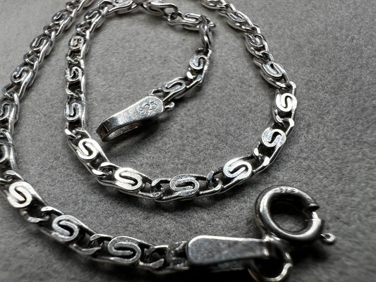 This sterling silver bracelet showcases a refined scroll link design, distinguishing it from standard chain styles. Expertly crafted for both durability and elegance, it offers a sophisticated accessory that enhances any wardrobe.