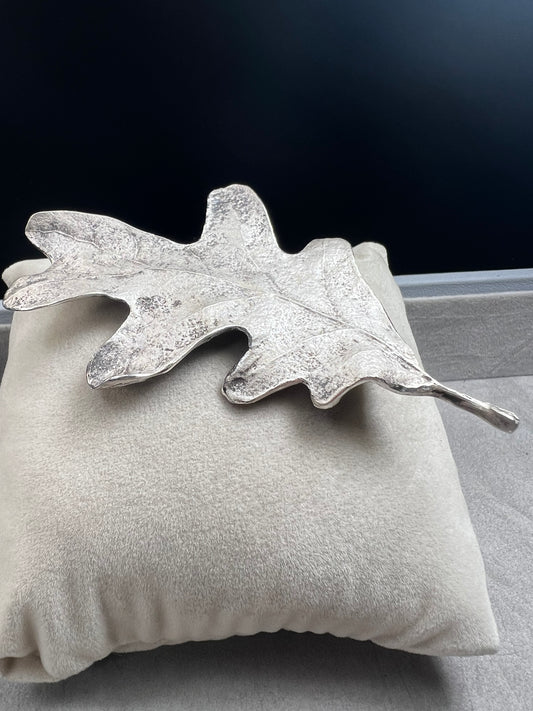 Shaped like an oak leaf, this sterling silver brooch captures nature’s beauty in exquisite detail. Its realistic design makes it a standout piece wherever it’s worn.