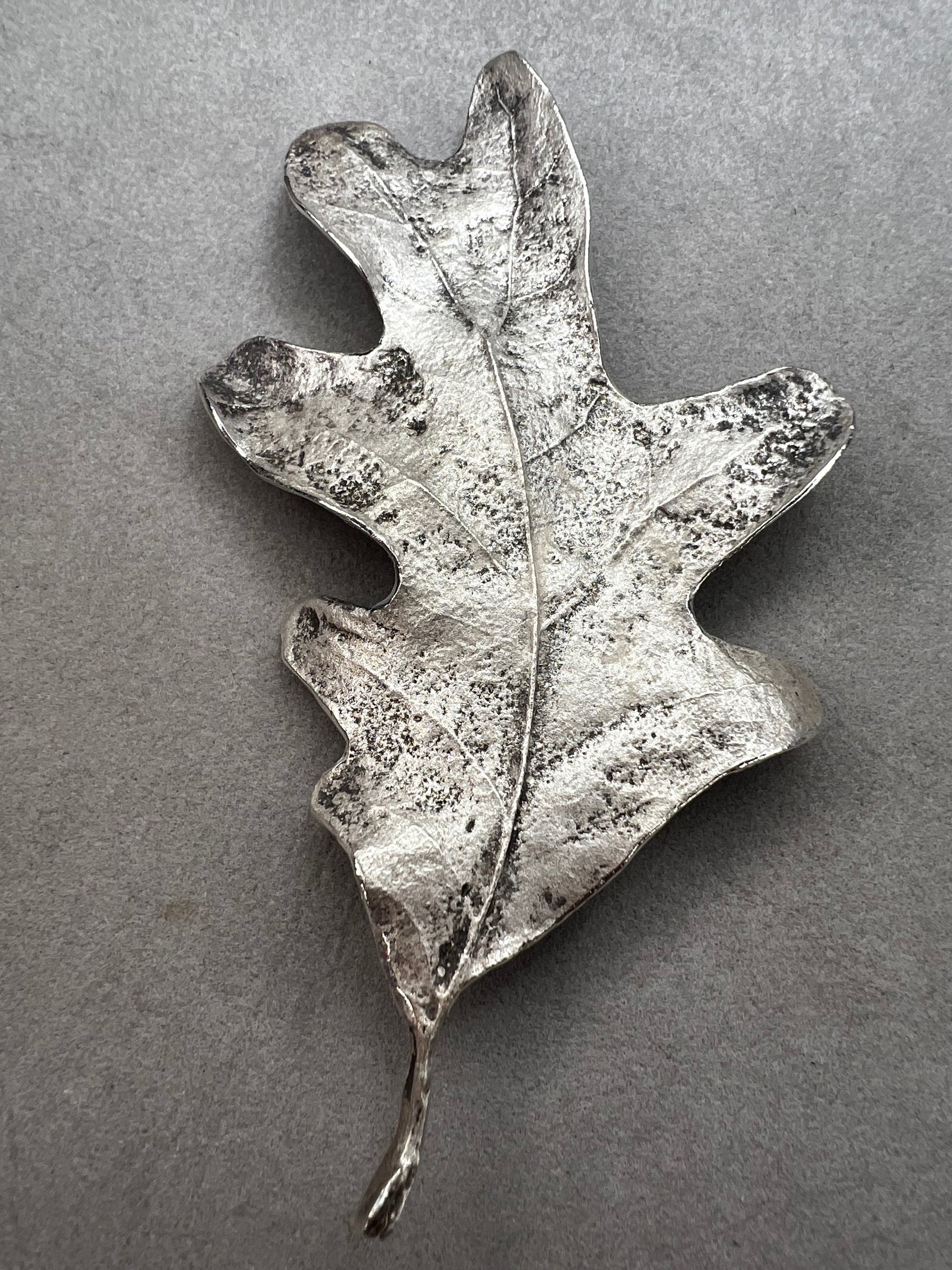 Shaped like an oak leaf, this sterling silver brooch captures nature’s beauty in exquisite detail. Its realistic design makes it a standout piece wherever it’s worn.