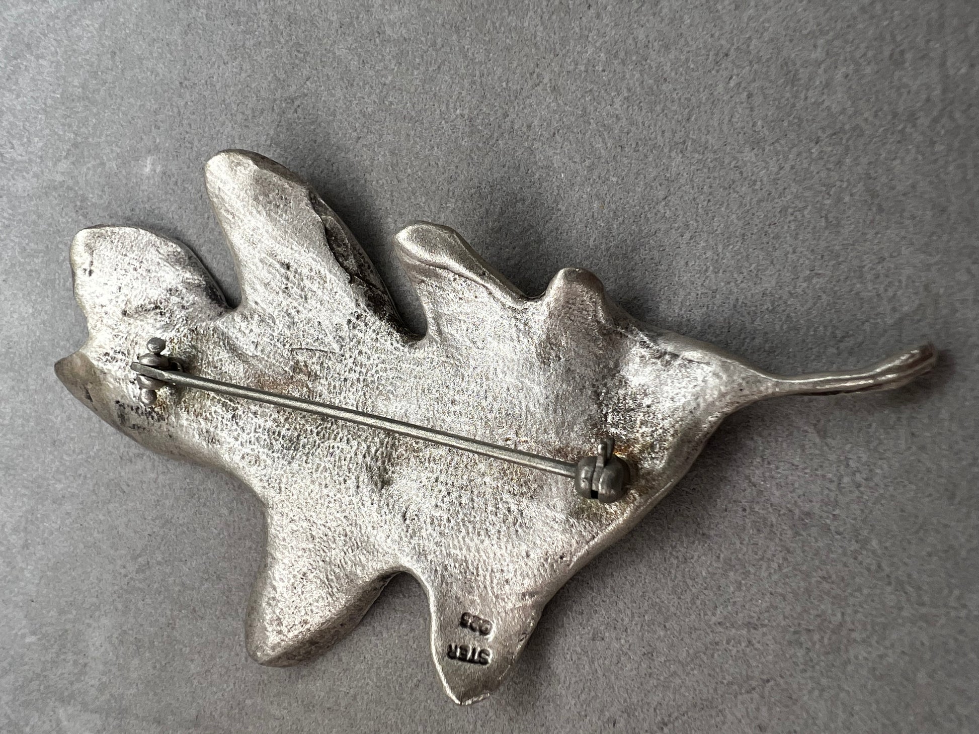 Shaped like an oak leaf, this sterling silver brooch captures nature’s beauty in exquisite detail. Its realistic design makes it a standout piece wherever it’s worn.