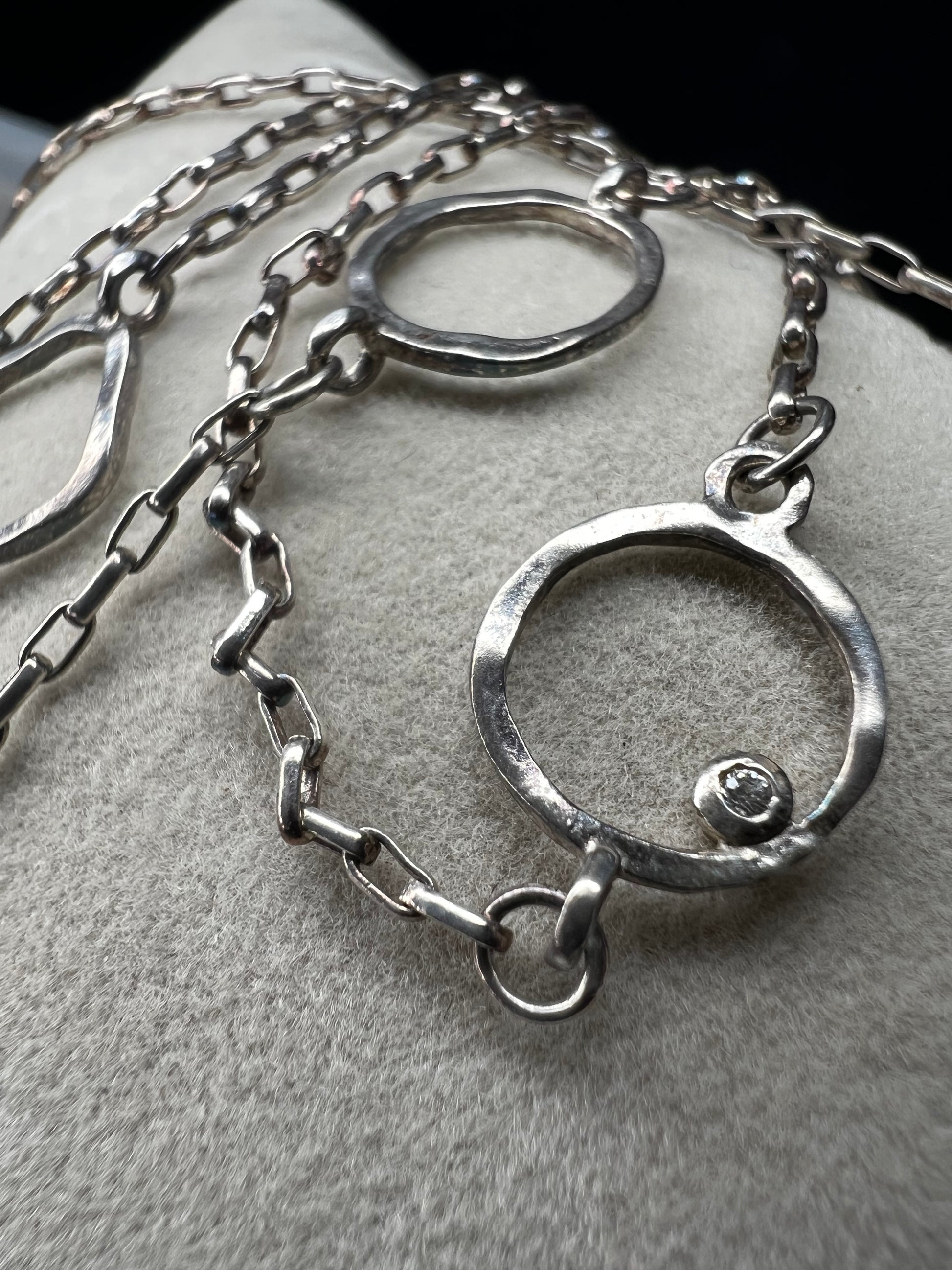This long sterling silver necklace is designed with intermittent geometric links along the length of the chain. Two of those large links feature a small diamond for a touch of flash in the light. At 34 inches, this can be wrapped twice for a layered look, or it can be worn long. Made by Silpada.