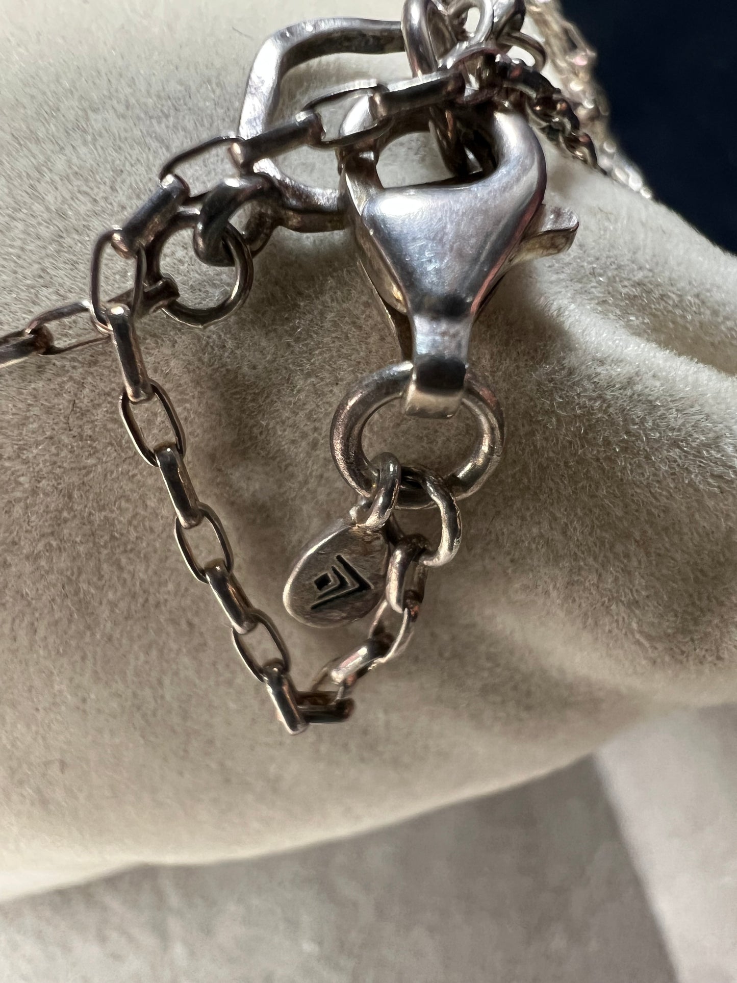 This long sterling silver necklace is designed with intermittent geometric links along the length of the chain. Two of those large links feature a small diamond for a touch of flash in the light. At 34 inches, this can be wrapped twice for a layered look, or it can be worn long. Made by Silpada.