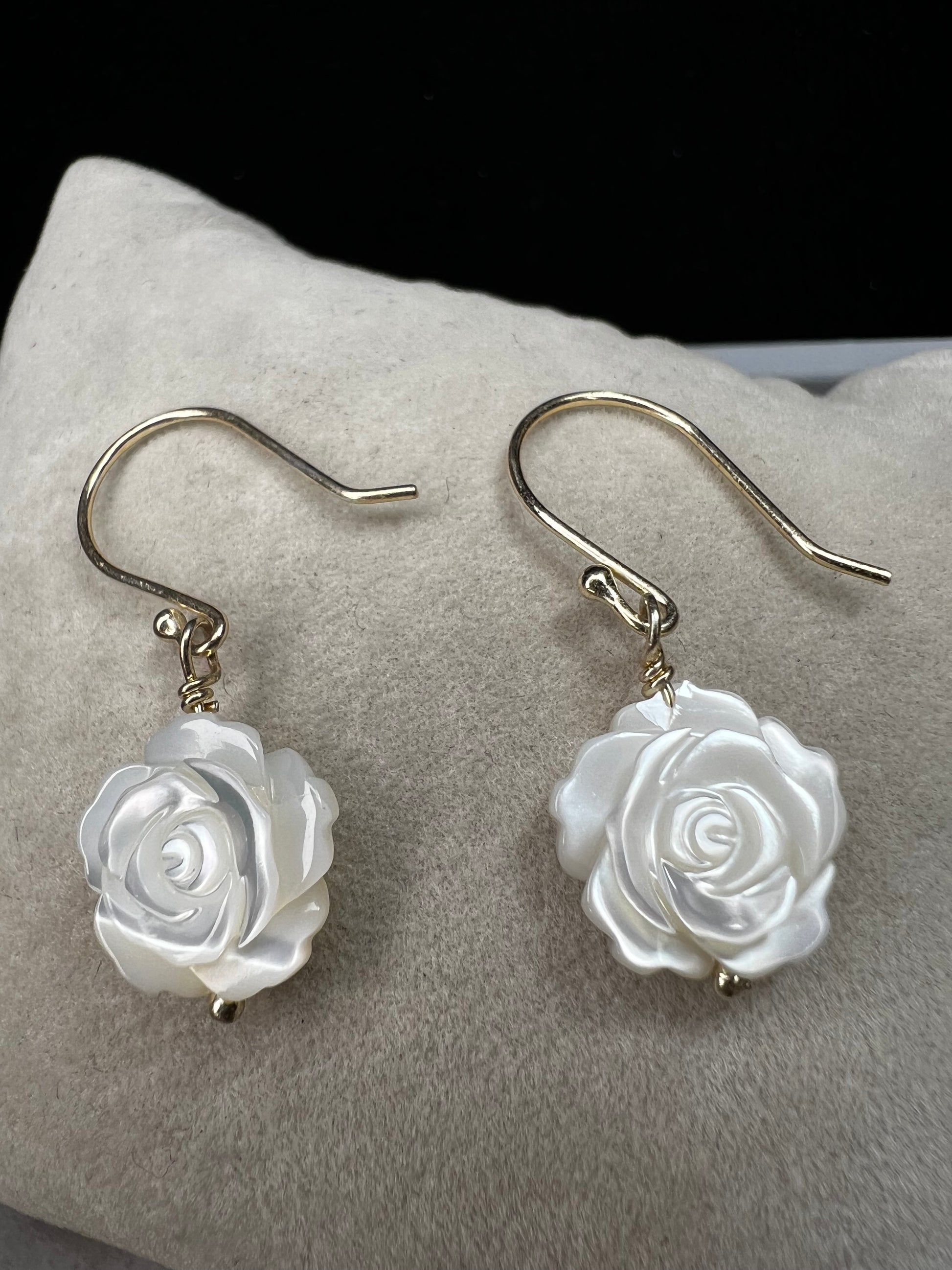 This stunning pair of earrings features a mother of pearl rose on each with gold washed sterling silver.