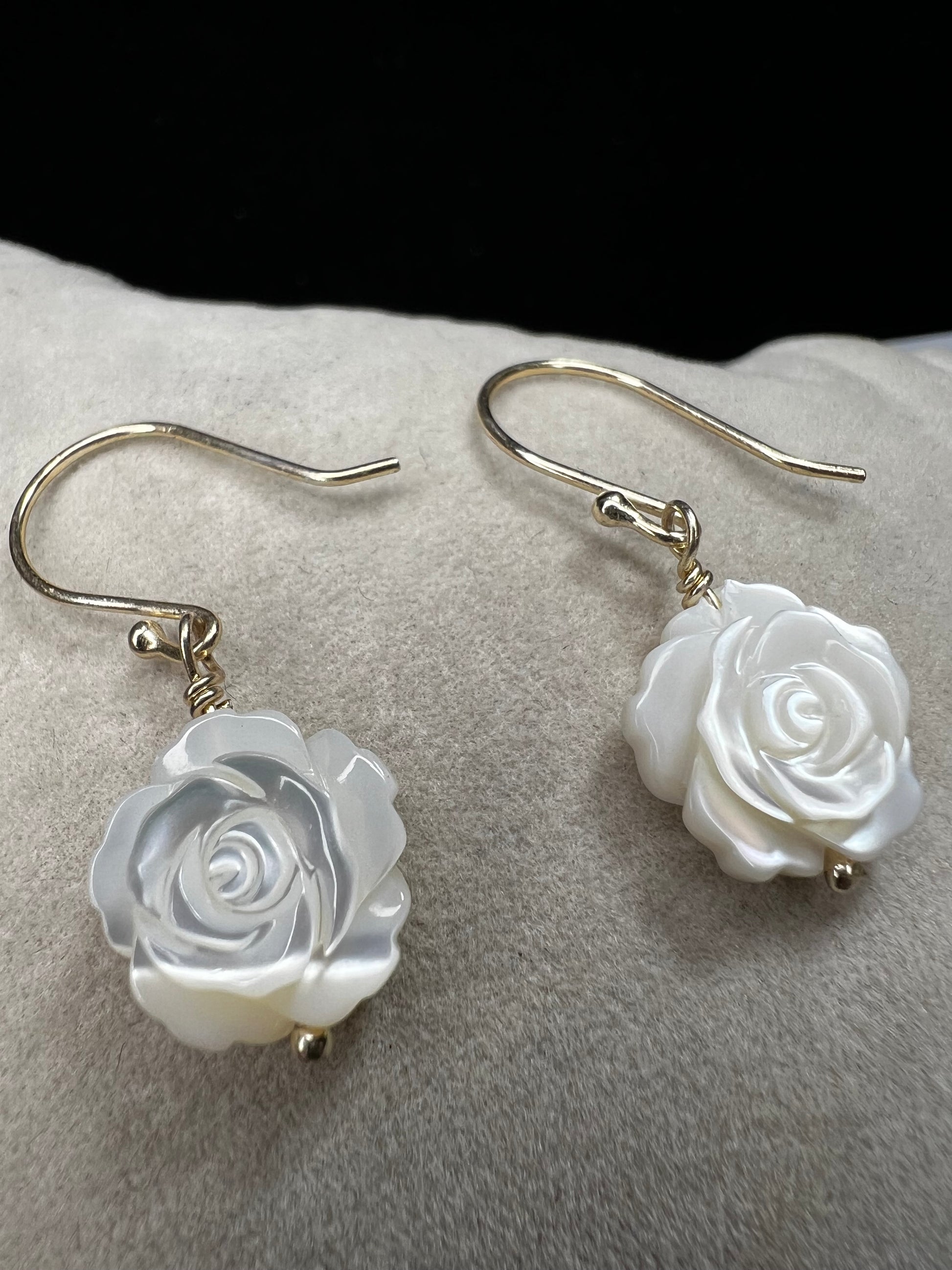This stunning pair of earrings features a mother of pearl rose on each with gold washed sterling silver.