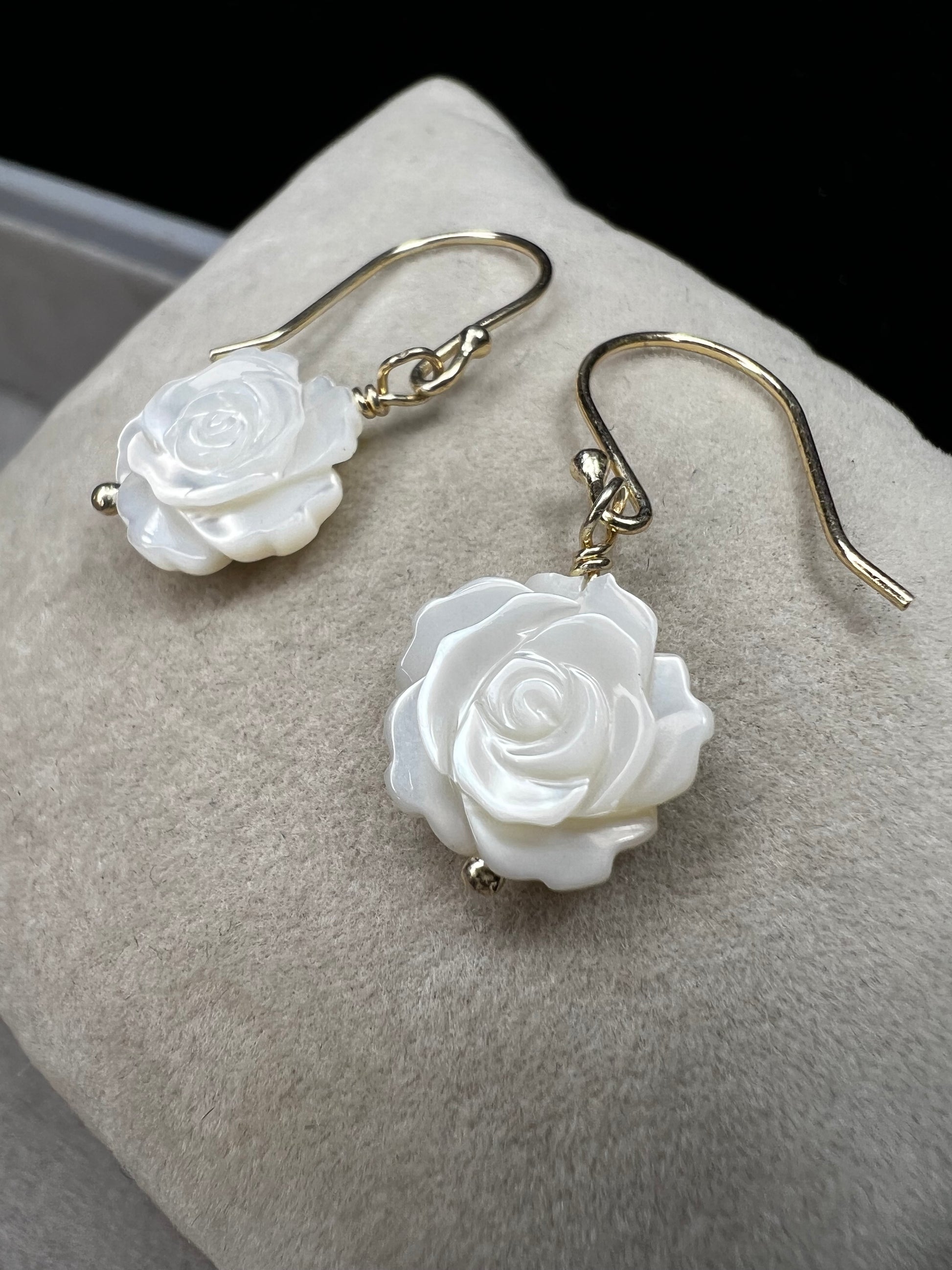 This stunning pair of earrings features a mother of pearl rose on each with gold washed sterling silver.