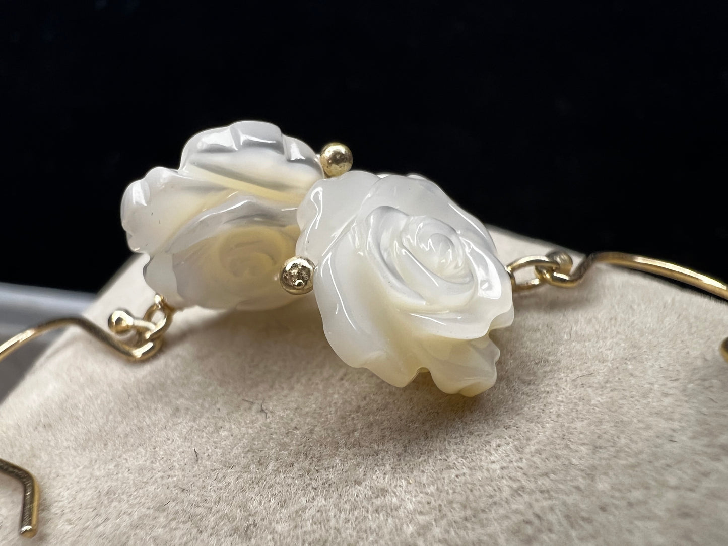 This stunning pair of earrings features a mother of pearl rose on each with gold washed sterling silver.