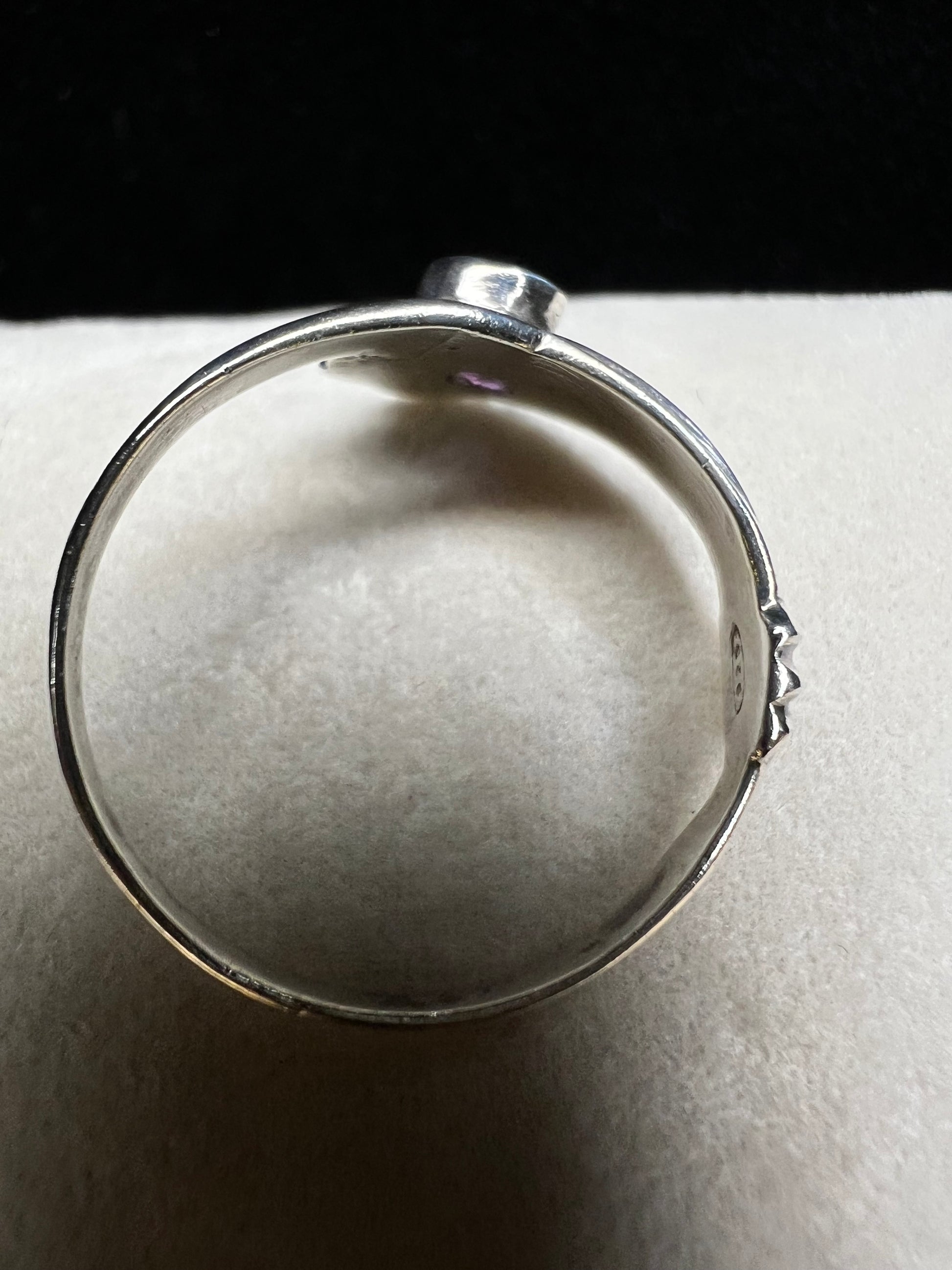 Add some individuality to your outfit with this sterling silver ring. Its unique design features an amethyst front and center.