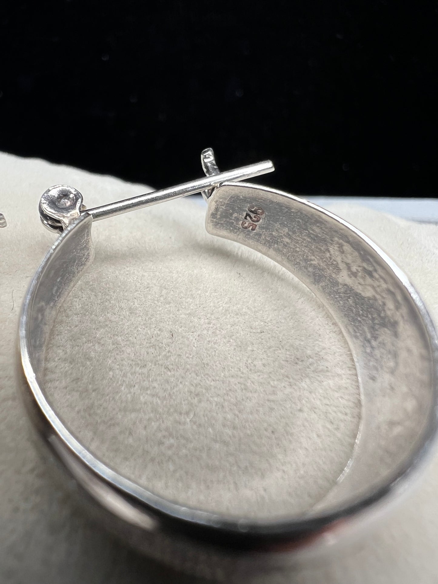 This vintage pair of sterling silver hoop earrings feature an etched design that resembles a snake wrapping around each earring.