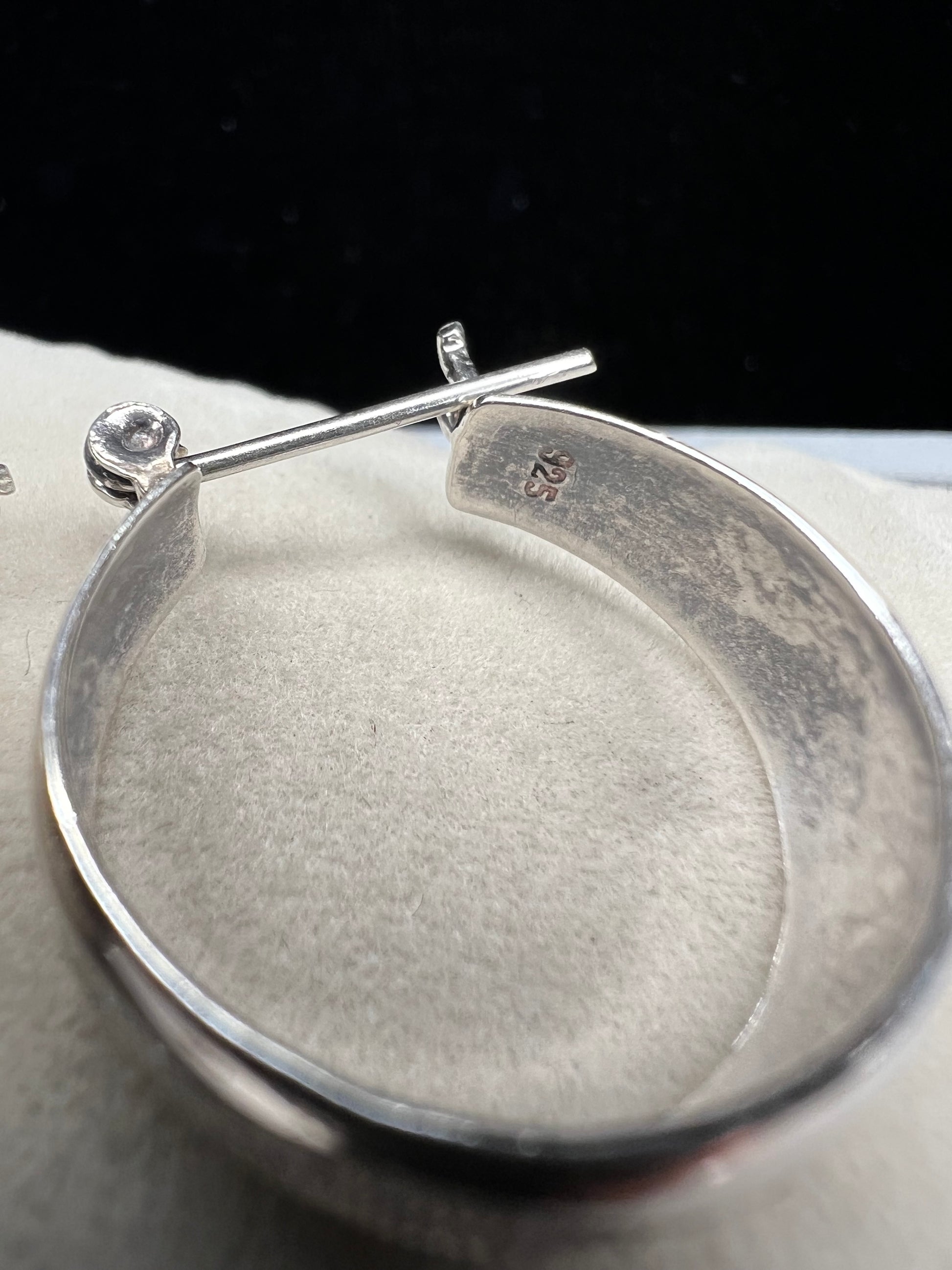 This vintage pair of sterling silver hoop earrings feature an etched design that resembles a snake wrapping around each earring.