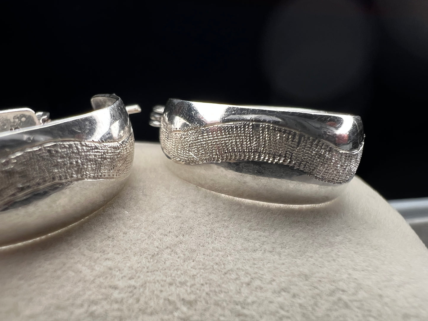 This vintage pair of sterling silver hoop earrings feature an etched design that resembles a snake wrapping around each earring.