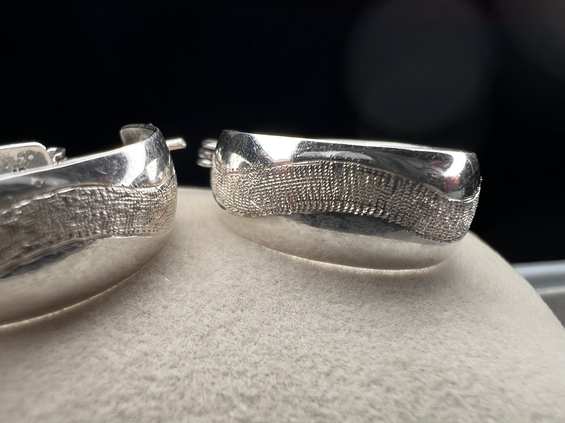 This vintage pair of sterling silver hoop earrings feature an etched design that resembles a snake wrapping around each earring.